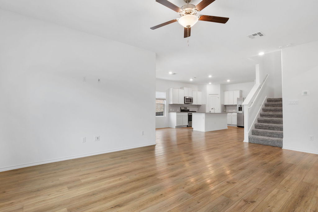 1205 Sweetspire Street Leander, TX 78641 - Photo 10 of 31 Unfurnished living room featuring stairway, light wood finished floors, recessed lighting, and a ceiling fan