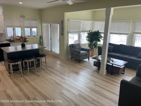 a living room with furniture a potted plant wooden floor and a table