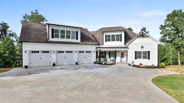 a front view of a house with yard and parking