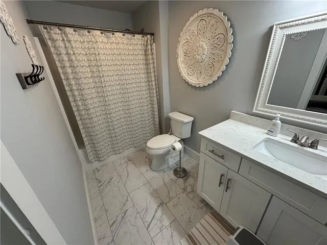 a bathroom with a toilet a sink and a mirror