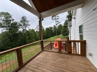 a view of a balcony with wooden floor and outdoor seating