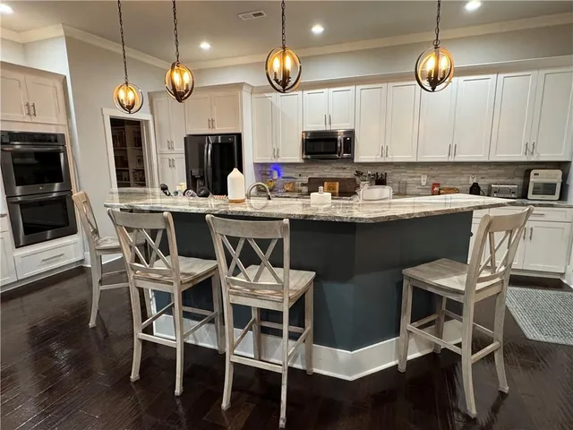 a kitchen with a dining table chairs and white cabinets