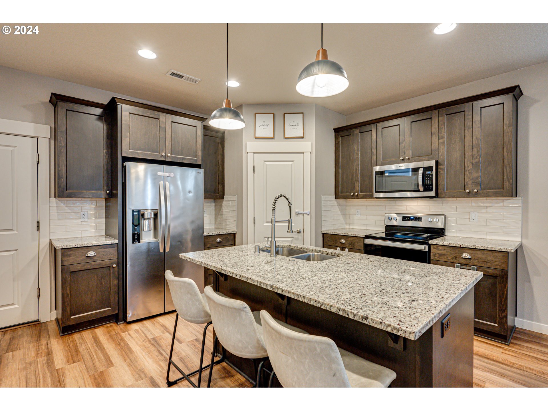 7252 South 13th Street Ridgefield, WA 98642 - Photo 5 of 29 a kitchen with granite countertop a stove refrigerator and microwave