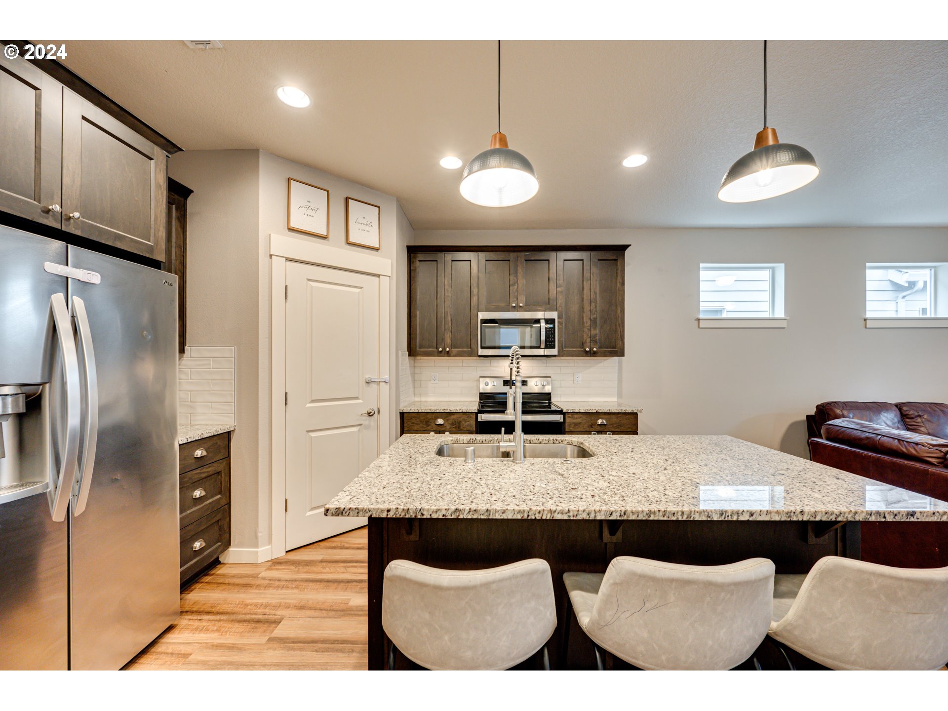 7252 South 13th Street Ridgefield, WA 98642 - Photo 7 of 29 a kitchen with kitchen island granite countertop a refrigerator a stove a sink a kitchen island with a dining table and chairs