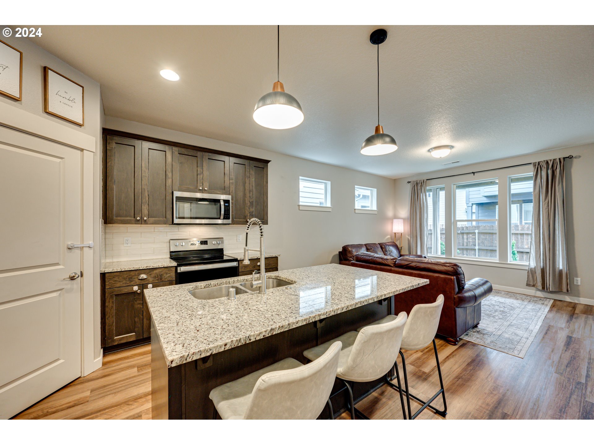 7252 South 13th Street Ridgefield, WA 98642 - Photo 8 of 29 a kitchen with stainless steel appliances granite countertop a stove a refrigerator a kitchen island a dining table and chairs
