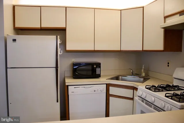 a kitchen with a sink a stove and cabinets