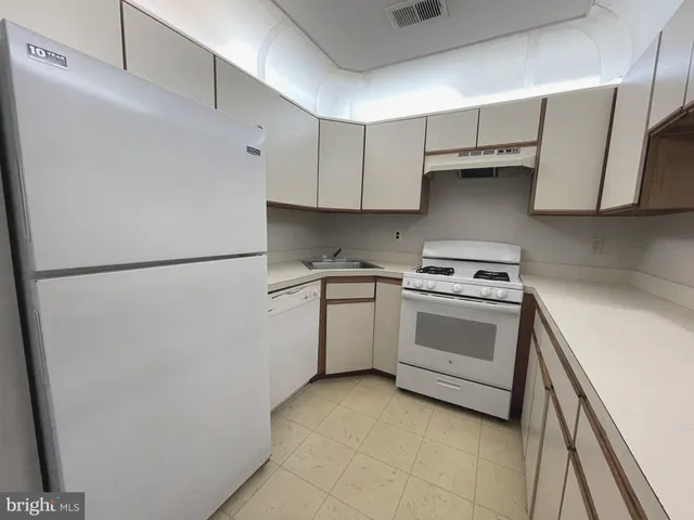 a kitchen with a stove top oven and cabinets