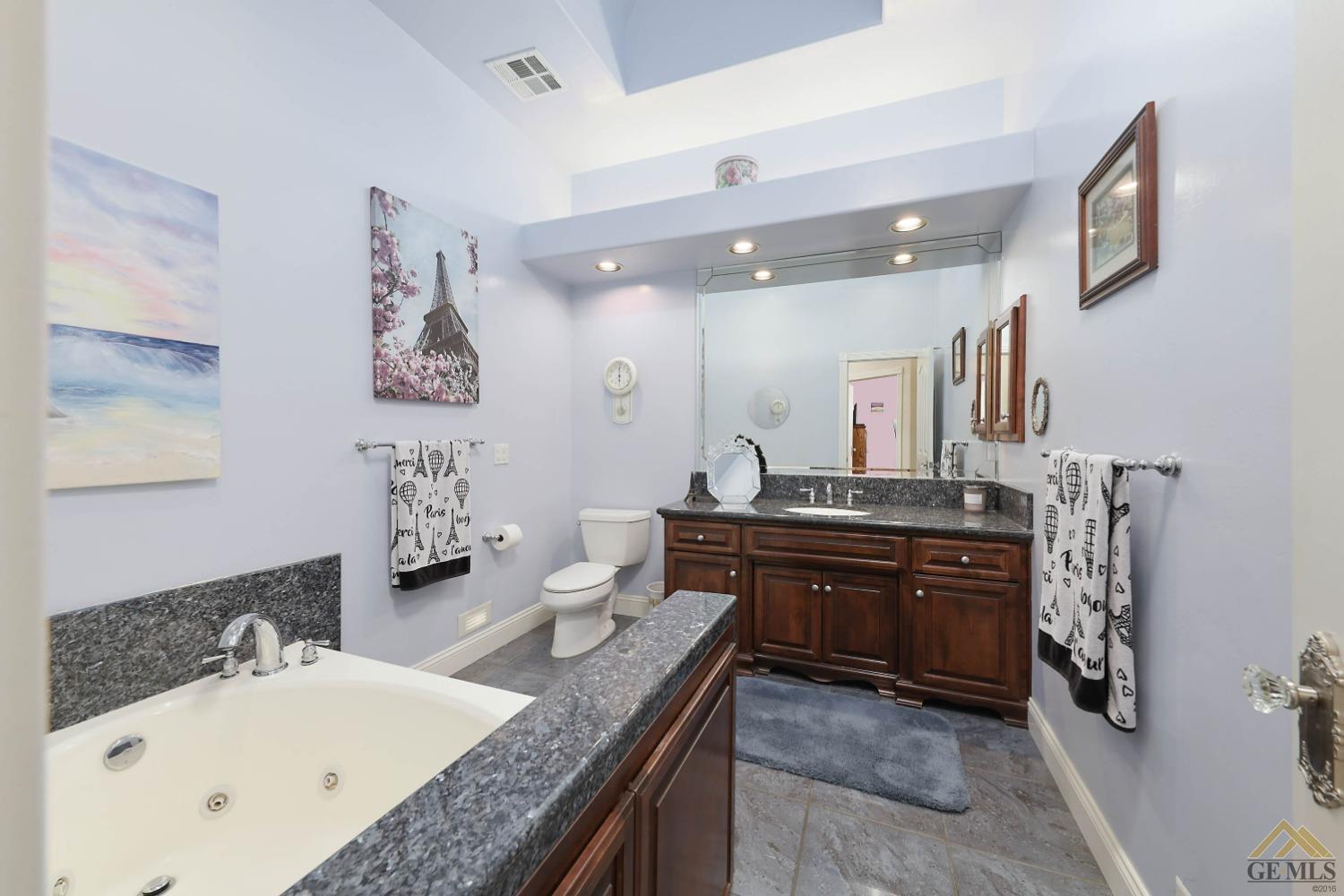 Undisclosed Address Bakersfield, CA 93312 - Photo 14 of 48 a bathroom with a granite countertop double vanity sink and mirror