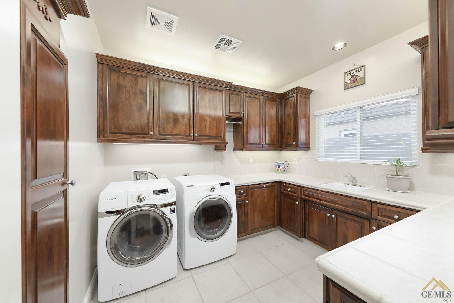 Undisclosed Address Bakersfield, CA 93312 - Photo 22 of 48 a kitchen with a sink a stove top oven and cabinets