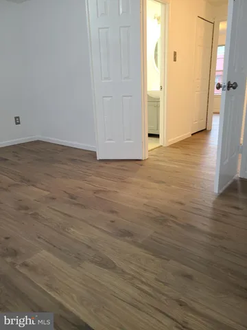 an empty room with wooden floor and a window