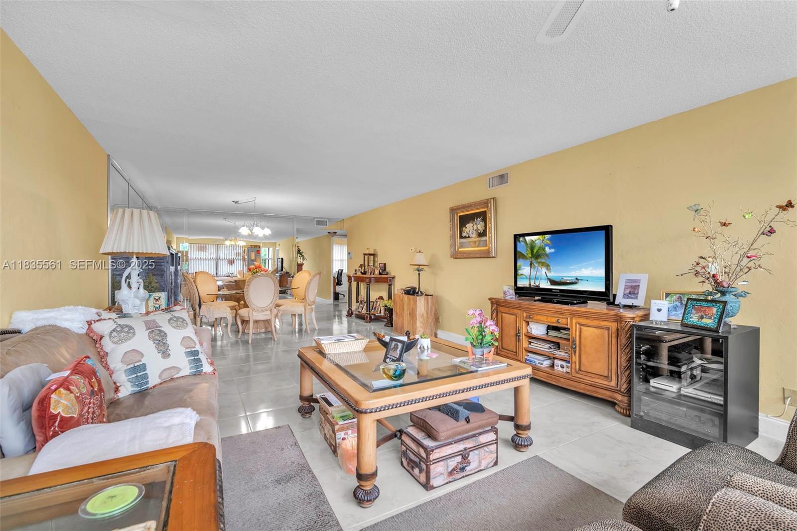 10400 Northwest 30th Court, Unit 305 Sunrise, FL 33322 - Photo 16 of 26 a living room with furniture and a flat screen tv
