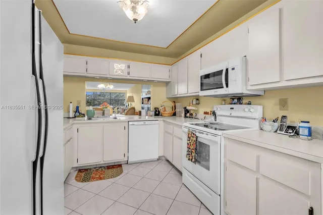 a kitchen with white cabinets and white appliances