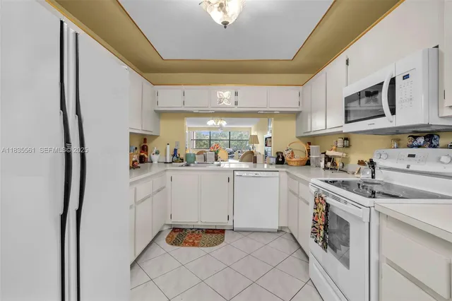 a kitchen with white cabinets and white appliances