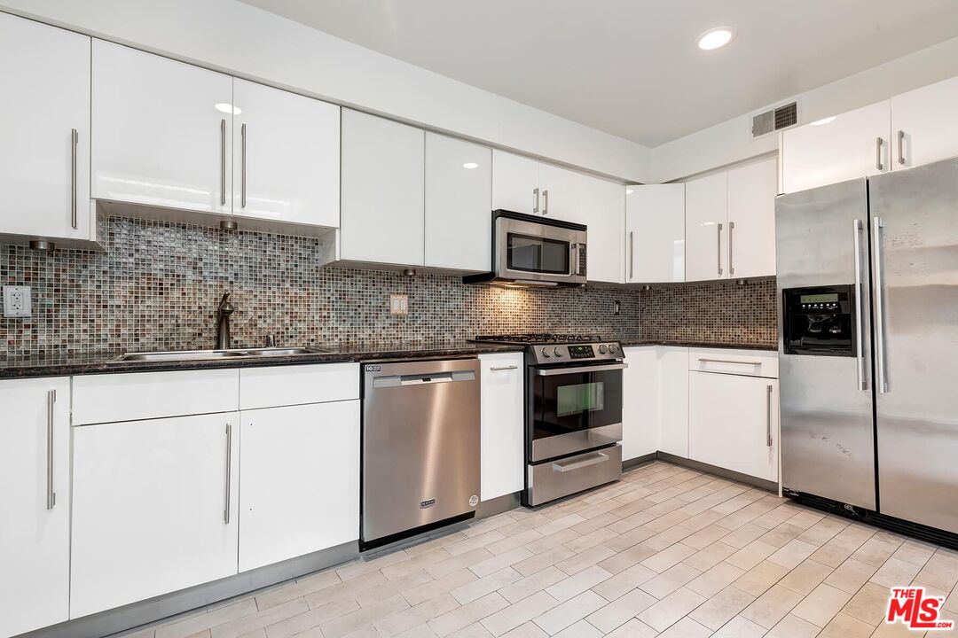 1013 21st Street, Unit B Santa Monica, CA 90403 - Photo 11 of 28 a kitchen with granite countertop white cabinets and stainless steel appliances