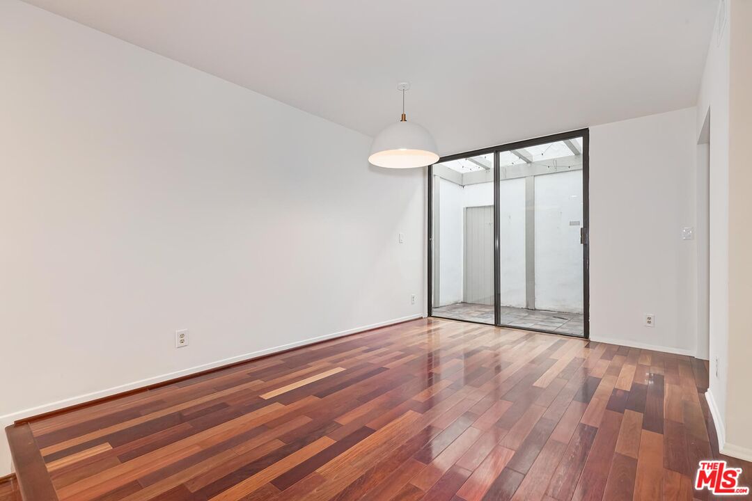1013 21st Street, Unit B Santa Monica, CA 90403 - Photo 8 of 28 a view of an empty room with wooden floor and a window