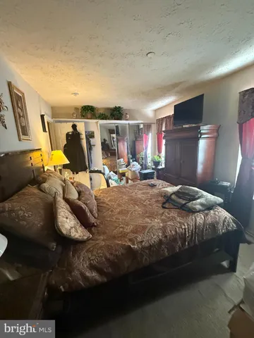 a bed sitting in a bedroom next to a lamp with window