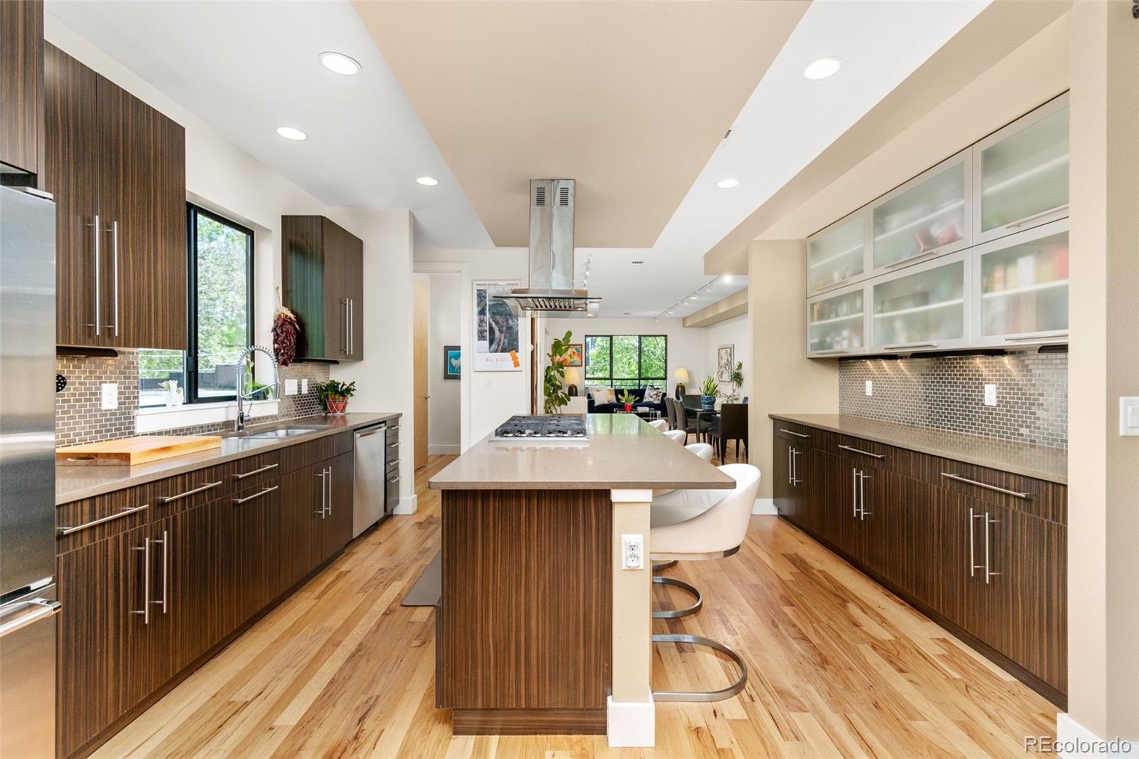 4515 West Moncrieff Place Denver, CO 80212 - Photo 10 of 29 a large kitchen with stainless steel appliances kitchen island granite countertop a large counter top a stove a sink and a refrigerator