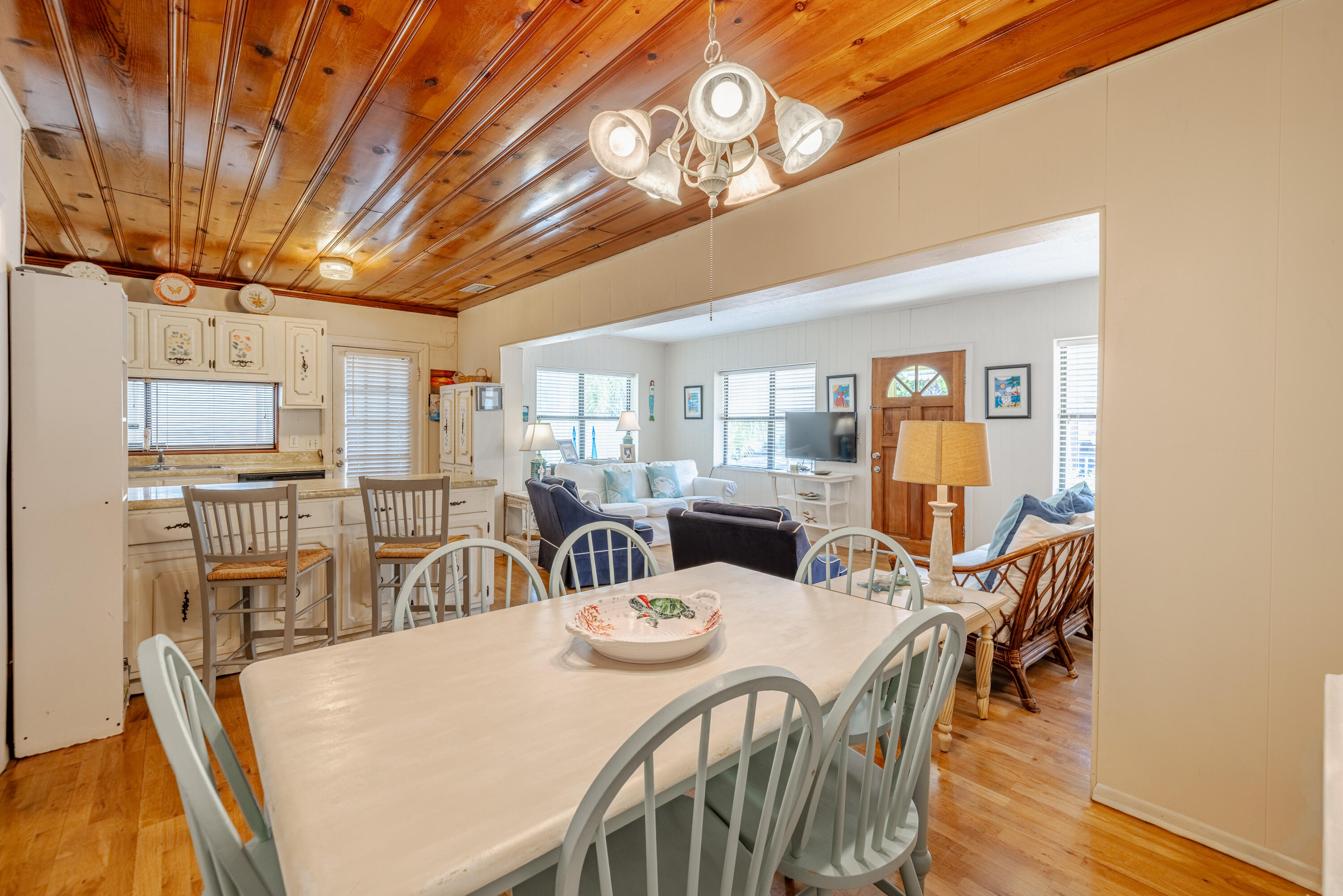 234 Sands Street Panama City Beach, FL 32413 - Photo 15 of 58 a view of a dining room with furniture and wooden floor
