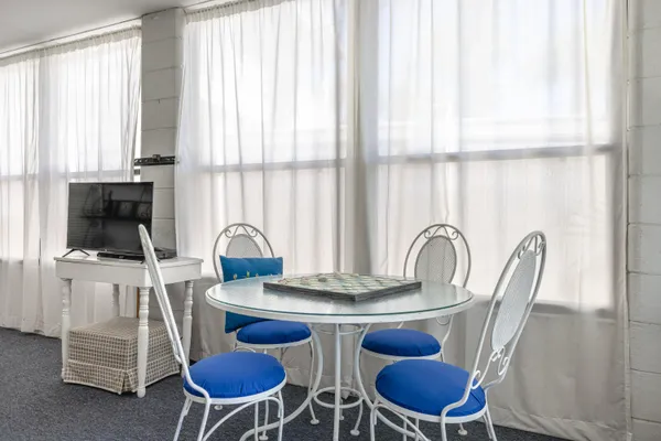 a dining room with furniture and a floor to ceiling window