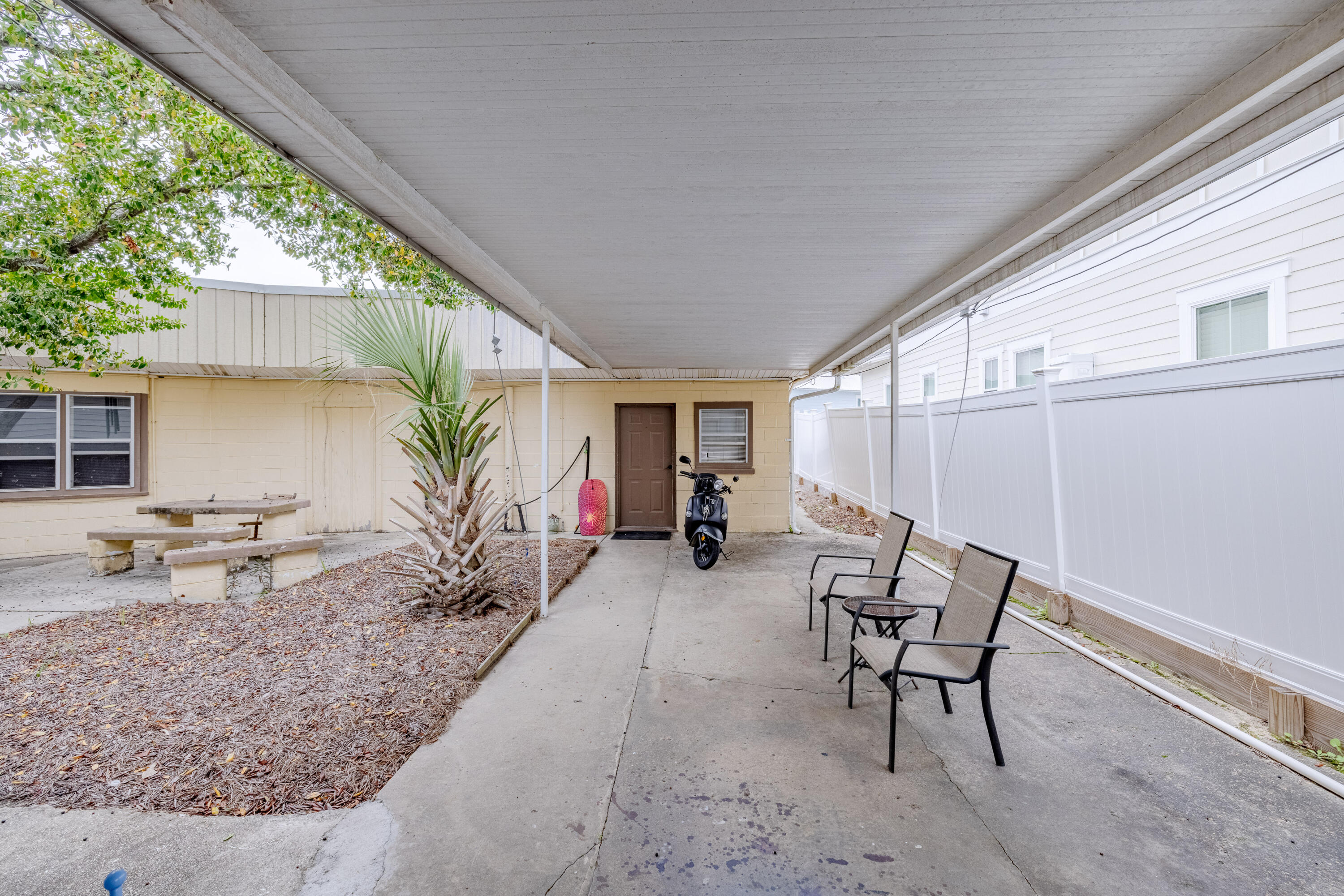 234 Sands Street Panama City Beach, FL 32413 - Photo 50 of 58 a view of a patio with table and chairs near a barbeque