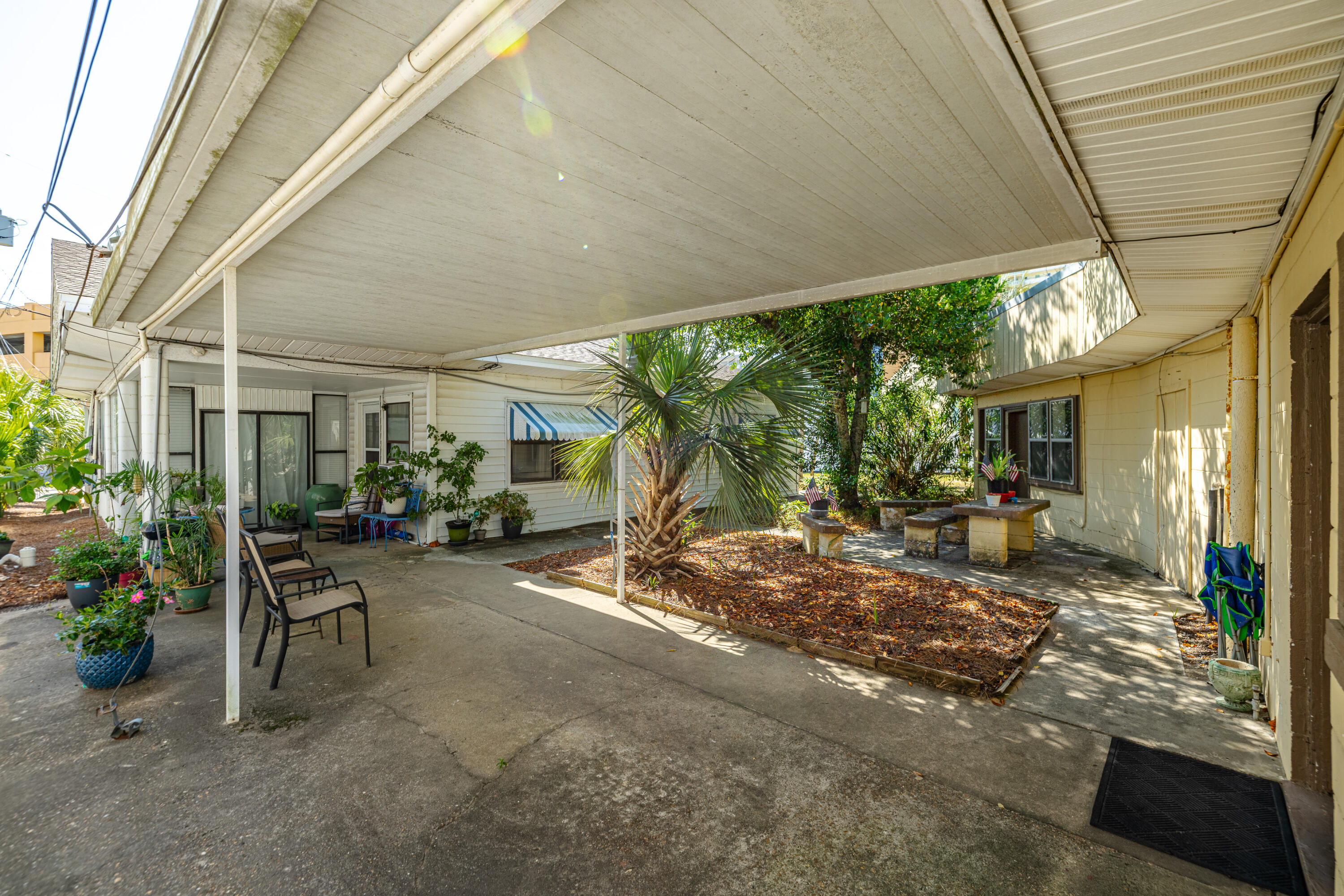 234 Sands Street Panama City Beach, FL 32413 - Photo 51 of 58 a view of a patio with table and chairs next to a yard