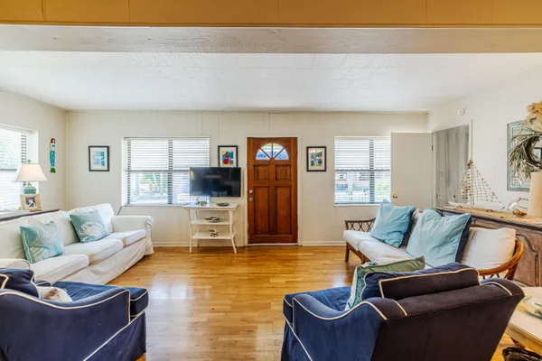 a living room with furniture and a wooden floor