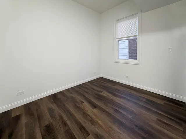 a view of a room with wooden floor and small window