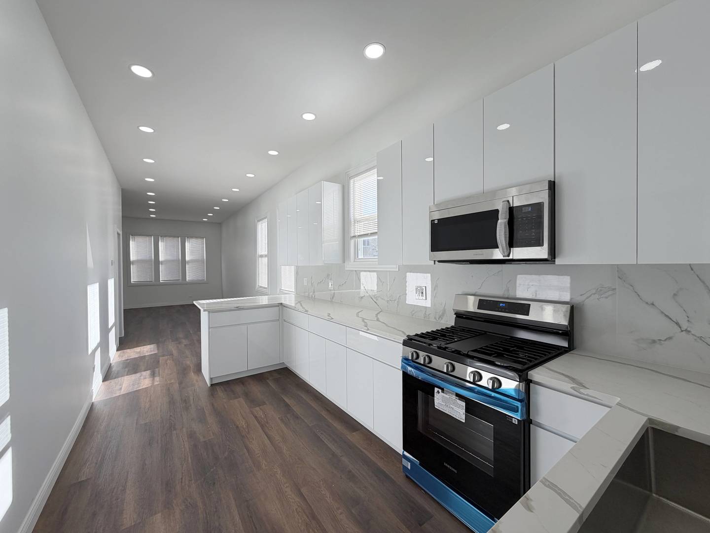 2982 South Lyman Street Chicago, IL 60608 - Photo 10 of 30 a large kitchen with stainless steel appliances kitchen island granite countertop a stove a sink and a microwave