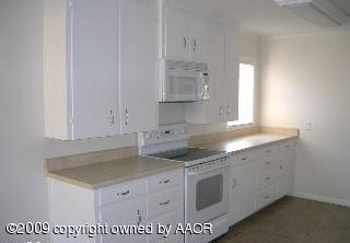 4116 South Lipscomb Street Amarillo, TX 79110 - Photo 4 of 10 a kitchen with granite countertop a sink a stove and cabinets