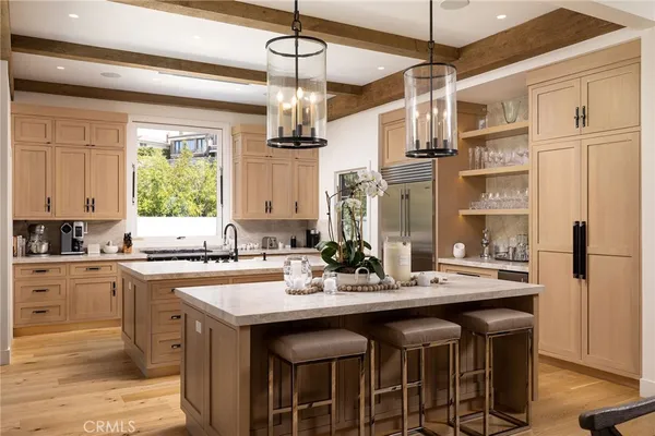 a kitchen with a stove a sink a dining table and chairs with wooden floor