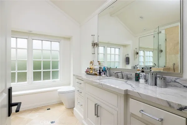 a bathroom with a granite countertop sink two mirror and shower