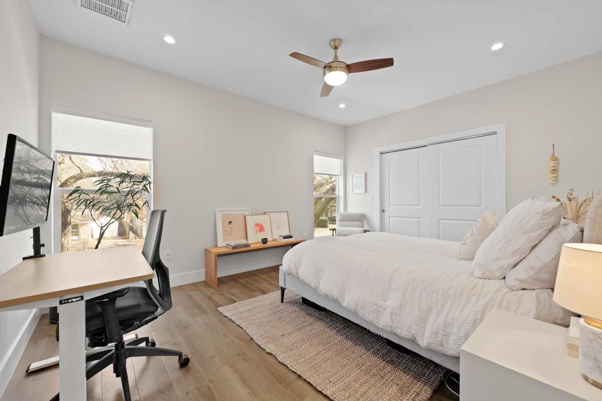 1102 1/2 Tillery Street, Unit 1 Austin, TX 78702 - Photo 31 of 38 a bedroom with a bed a desk and chair with wooden floor