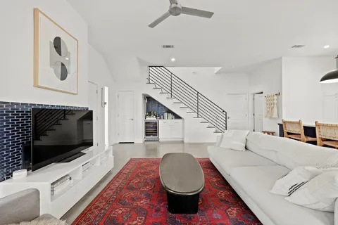 a living room with furniture a flat screen tv and kitchen view