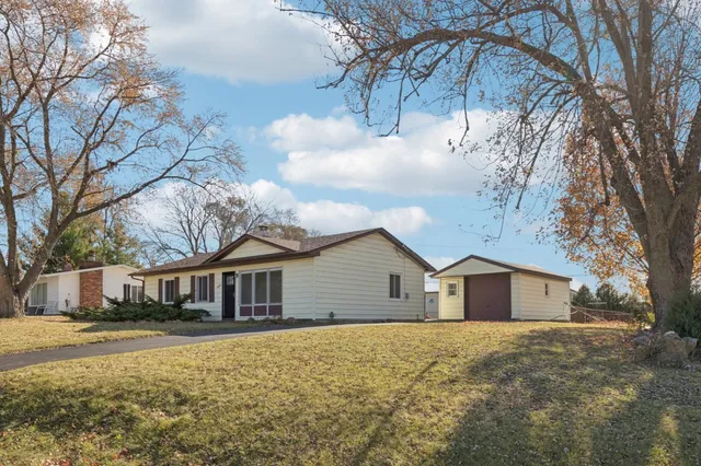a front view of house with yard and trees around
