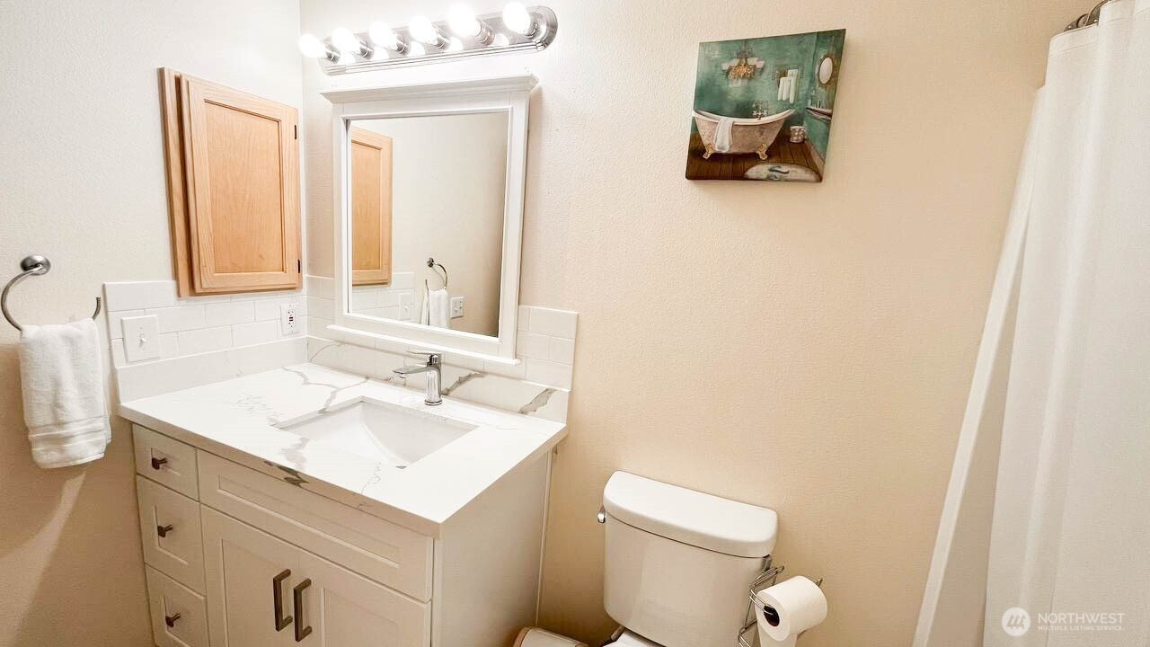 1001 West Casino Road, Unit G303 Everett, WA 98204 - Photo 21 of 22 a bathroom with a sink a toilet and mirror