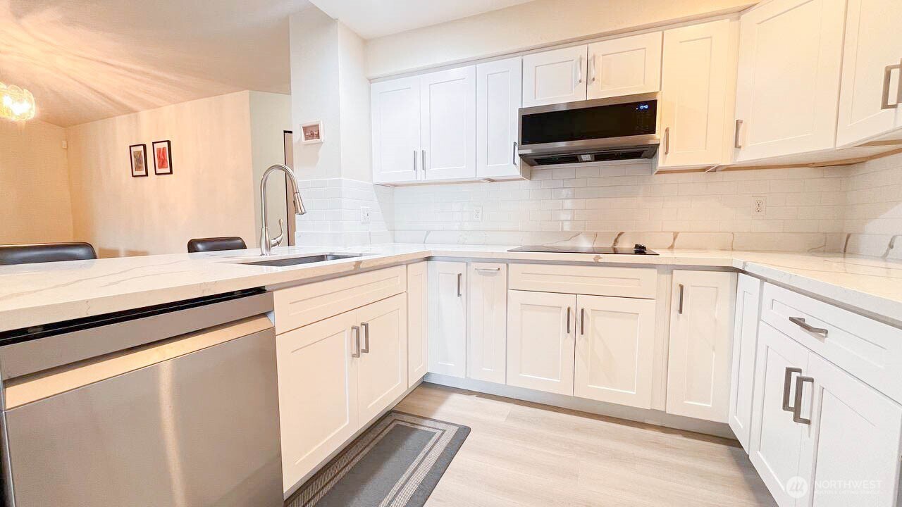1001 West Casino Road, Unit G303 Everett, WA 98204 - Photo 8 of 22 a kitchen with white cabinets stainless steel appliances and sink