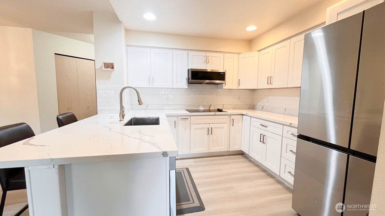1001 West Casino Road, Unit G303 Everett, WA 98204 - Photo 9 of 22 a kitchen with white cabinets and white appliances