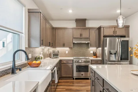 a kitchen with stainless steel appliances a sink stove and refrigerator