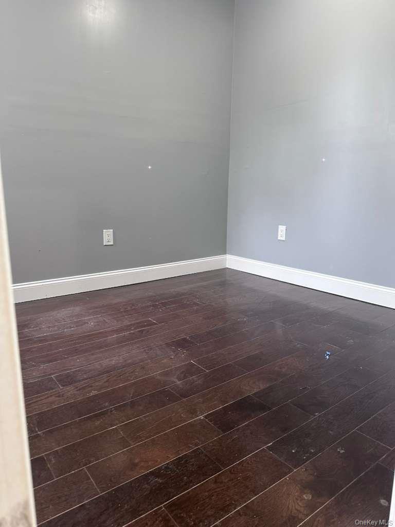 114-06 Inwood Street Queens, NY 11436 - Photo 5 of 18 Unfurnished room with dark wood-style floors and baseboards