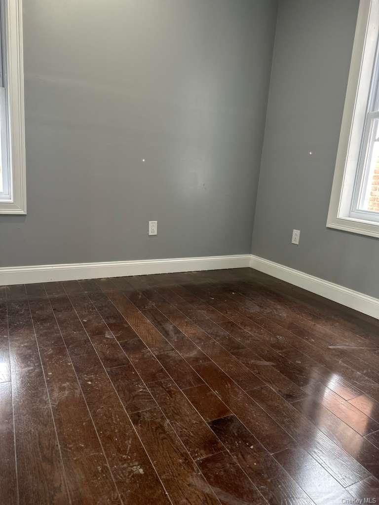 114-06 Inwood Street Queens, NY 11436 - Photo 7 of 18 Unfurnished room with healthy amount of natural light and dark wood-style floors