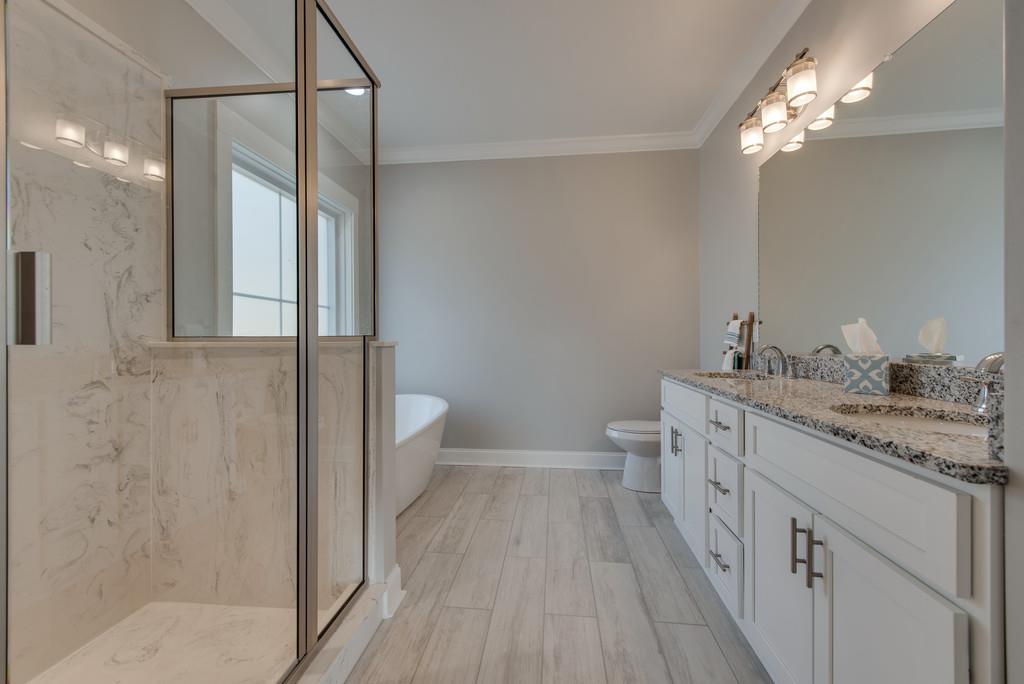 2107 Double Branch Road Columbia, TN 38401 - Photo 16 of 29 a bathroom with a granite countertop sink a toilet a shower and a mirror