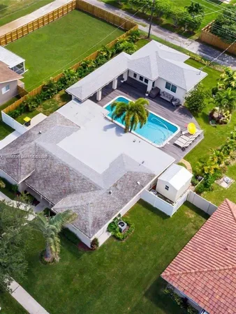 an aerial view of a house with a garden and swimming pool