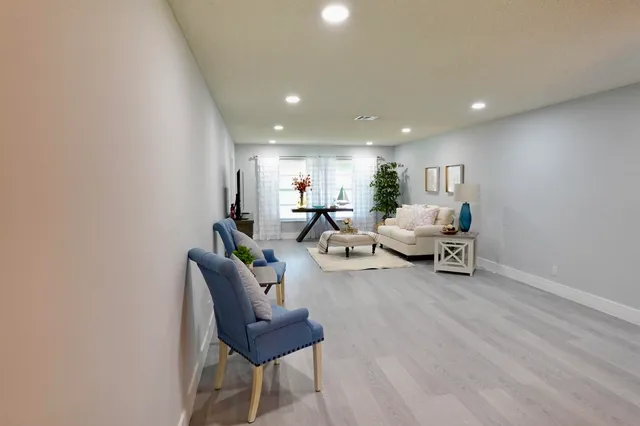 a living room with furniture and a wooden floor