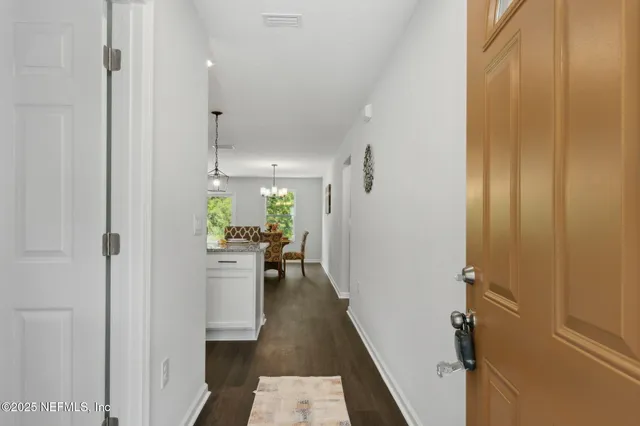 a view of a hallway and a dining room with furniture