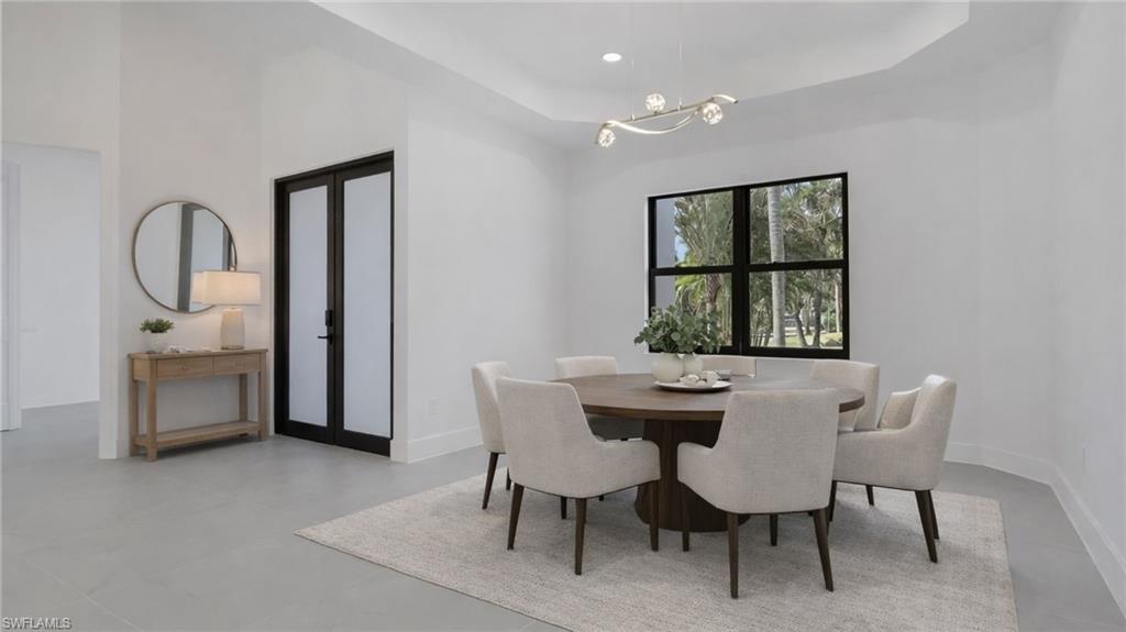 730 29th Street Southwest Naples, FL 34117 - Photo 10 of 50 Virtually Staged Dining area featuring a raised ceiling, french doors, a chandelier, and concrete flooring