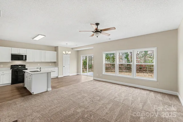 a view of an empty room with a kitchen