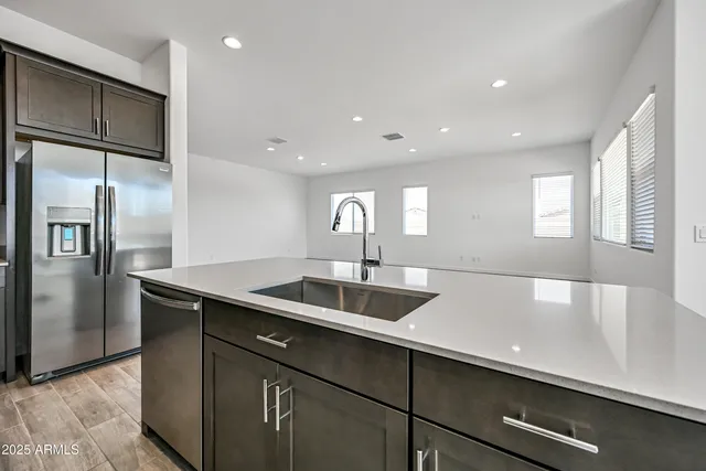 a kitchen with stainless steel appliances granite countertop a sink and a refrigerator