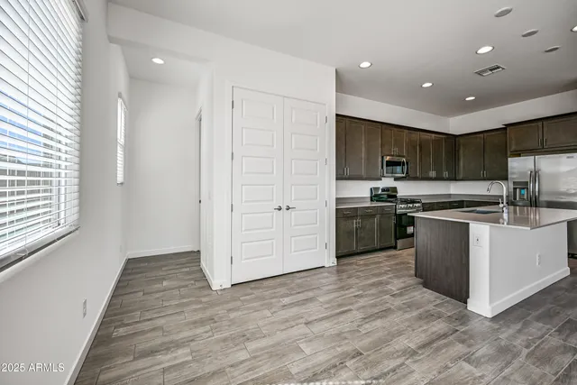 a kitchen with kitchen island granite countertop a refrigerator and a stove top oven