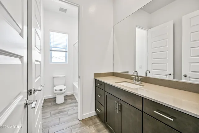 a bathroom with a granite countertop sink mirror vanity and toilet