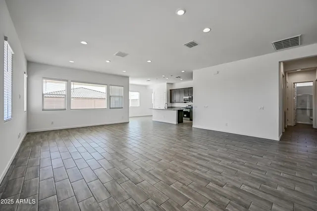 a view of empty room with kitchen and window
